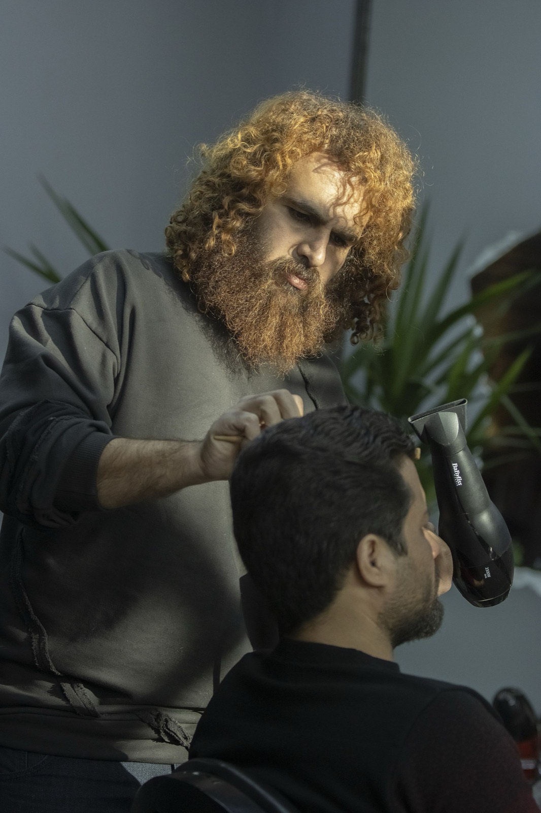 Stylist's hands sectioning a client's hair.