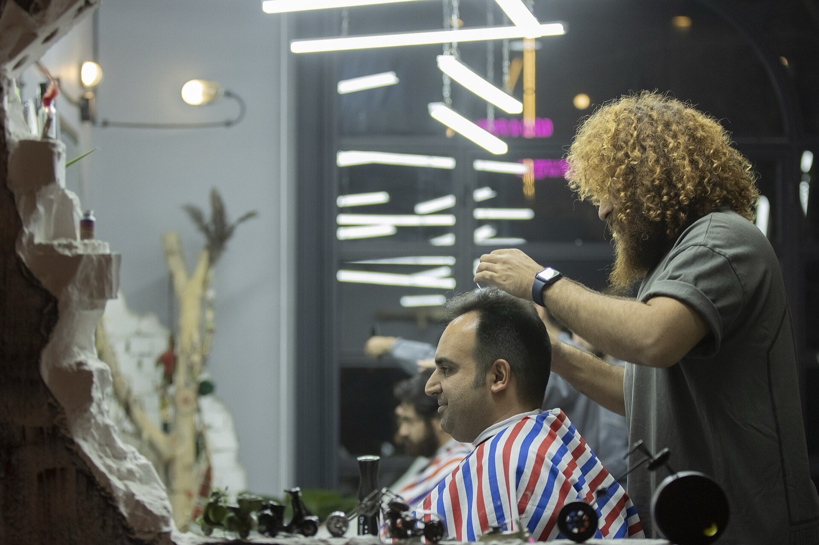 A stylist working on a client's hair in a calm, well-lit salon.