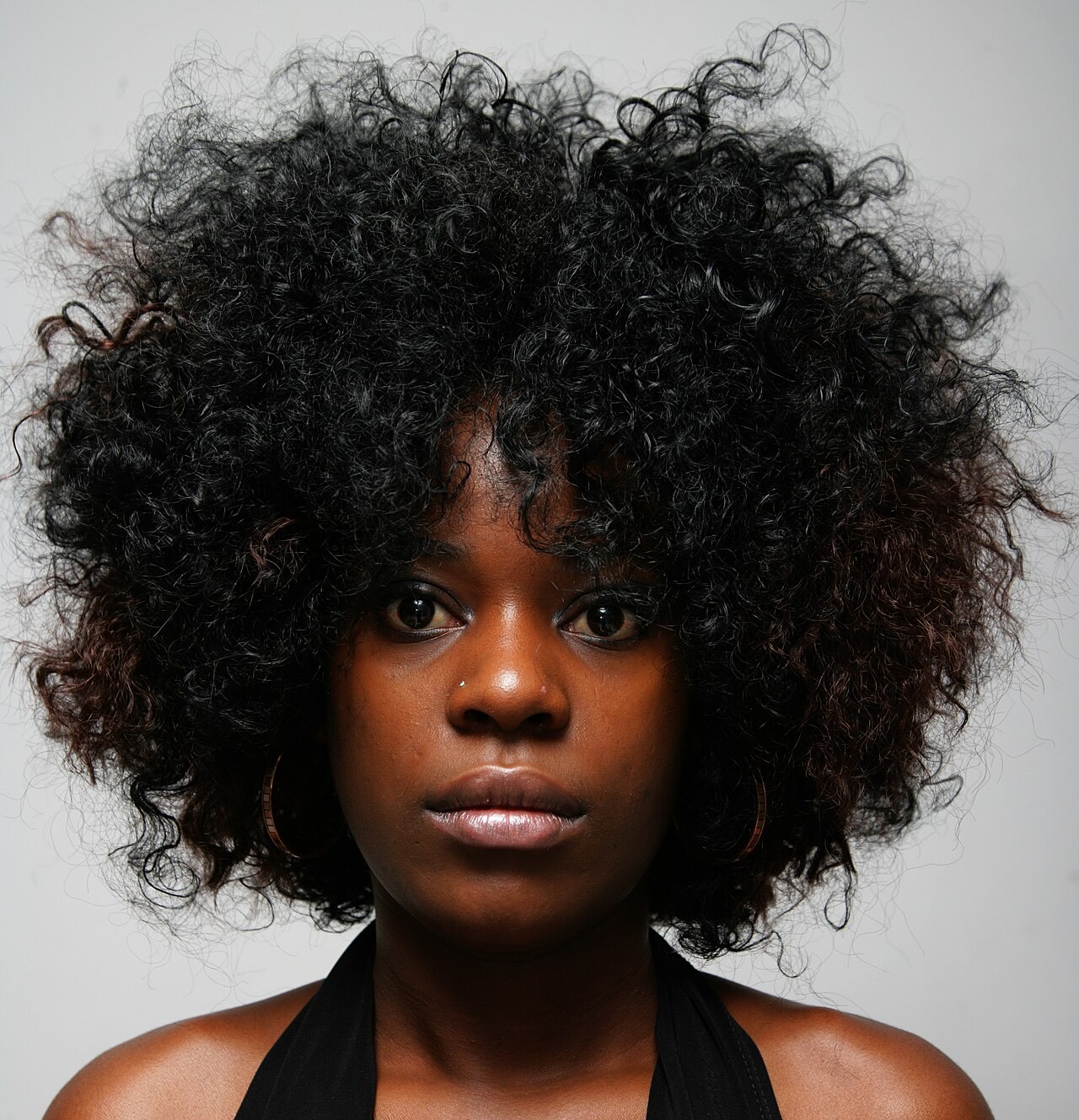 Close-up of textured, curly hair styled into a strong shape.